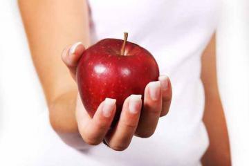 Hand mit einem Apfel